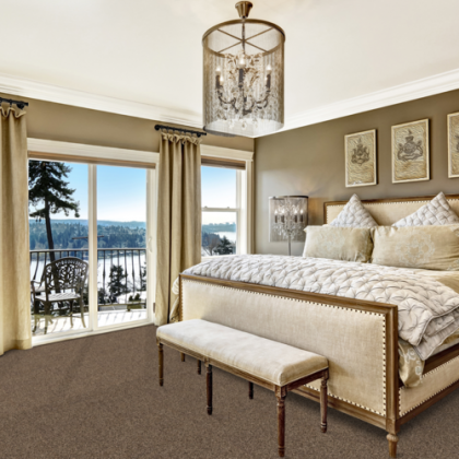 A bedroom with a large bed and a bench