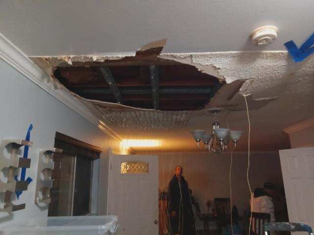Hole in ceiling reveals metal supports.