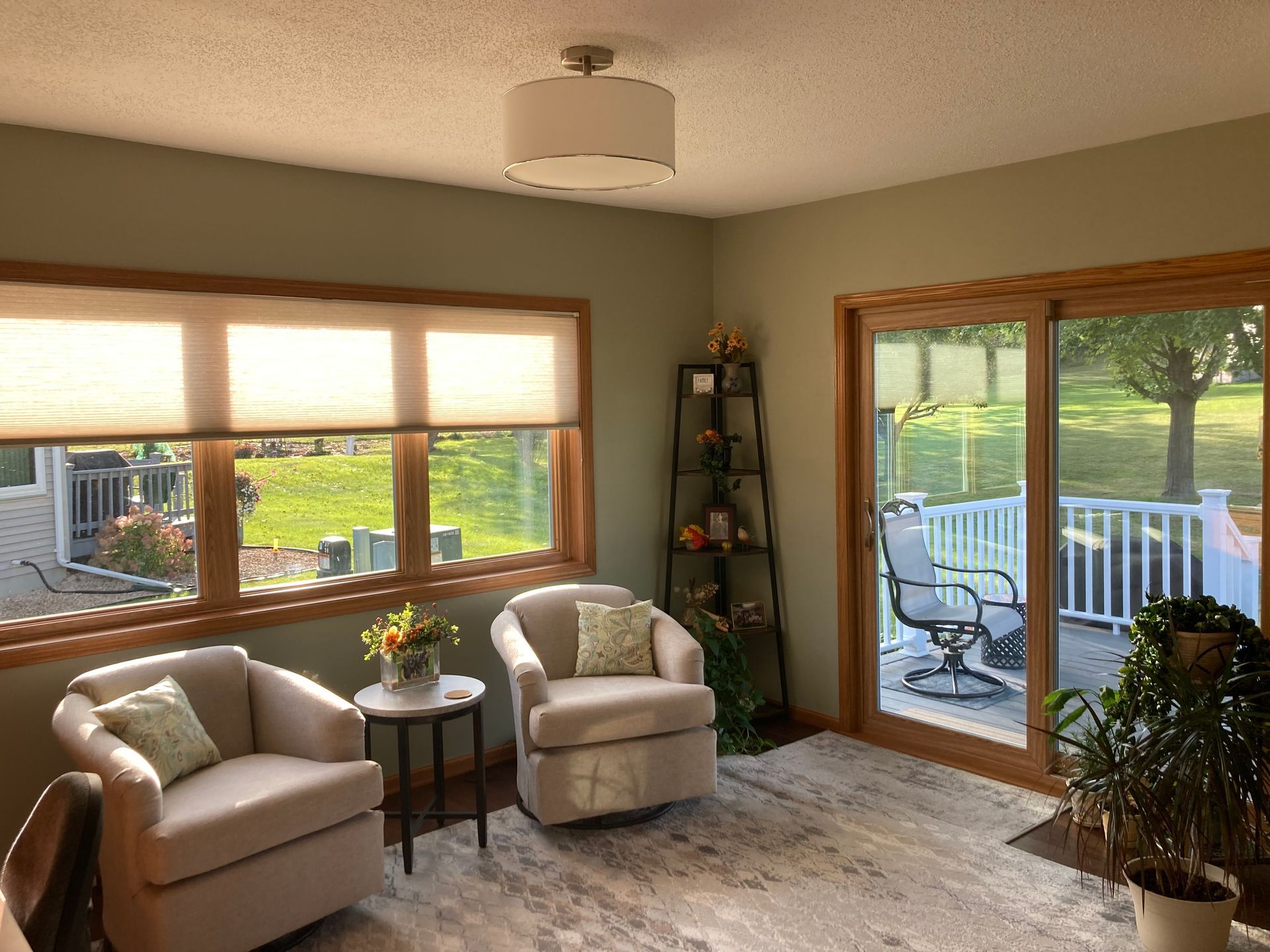 Cozy living room with two chairs, large window, sliding glass door, and a patio view