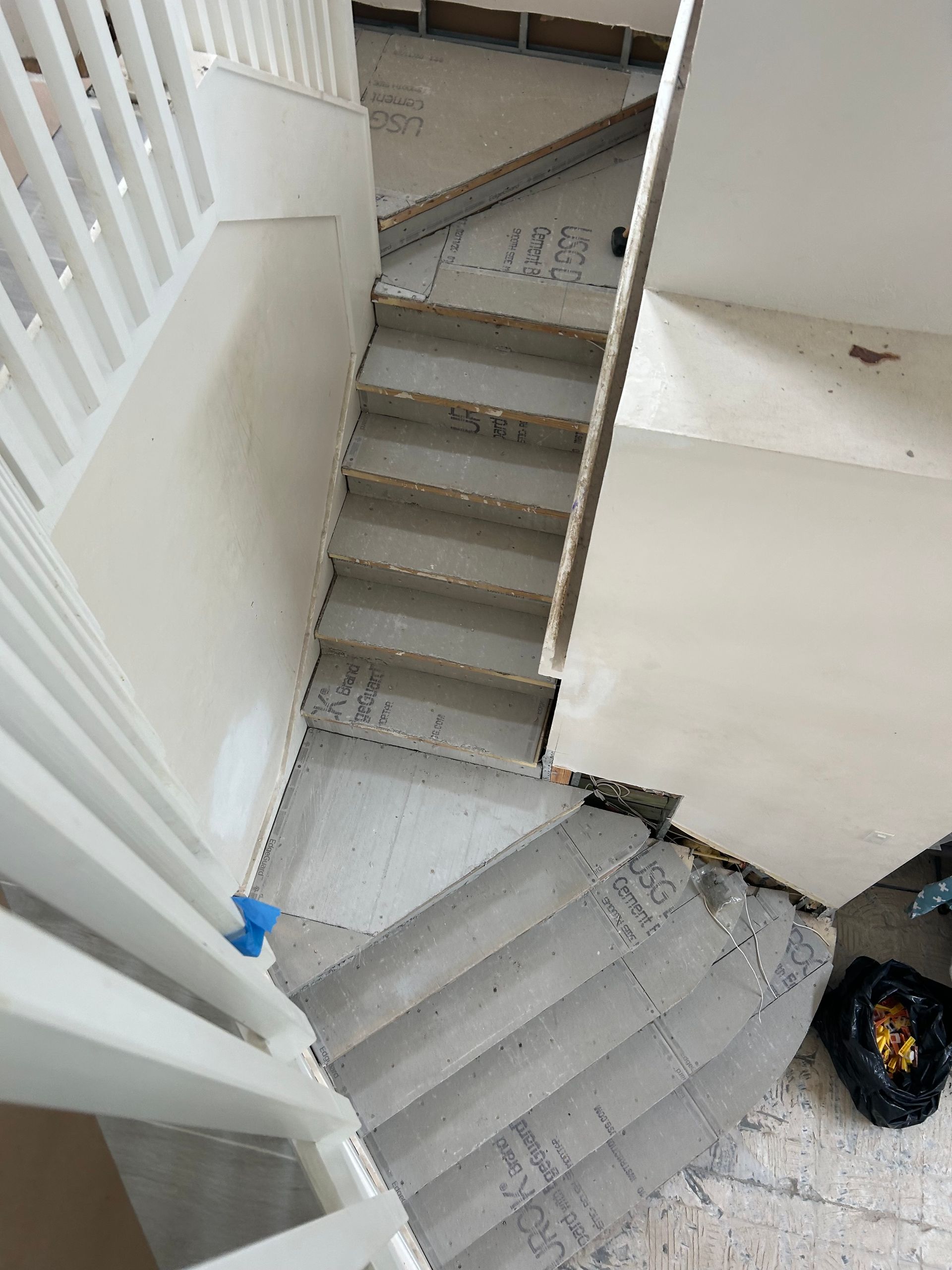 Indoor stairwell with two narrow gray staircases and white railings