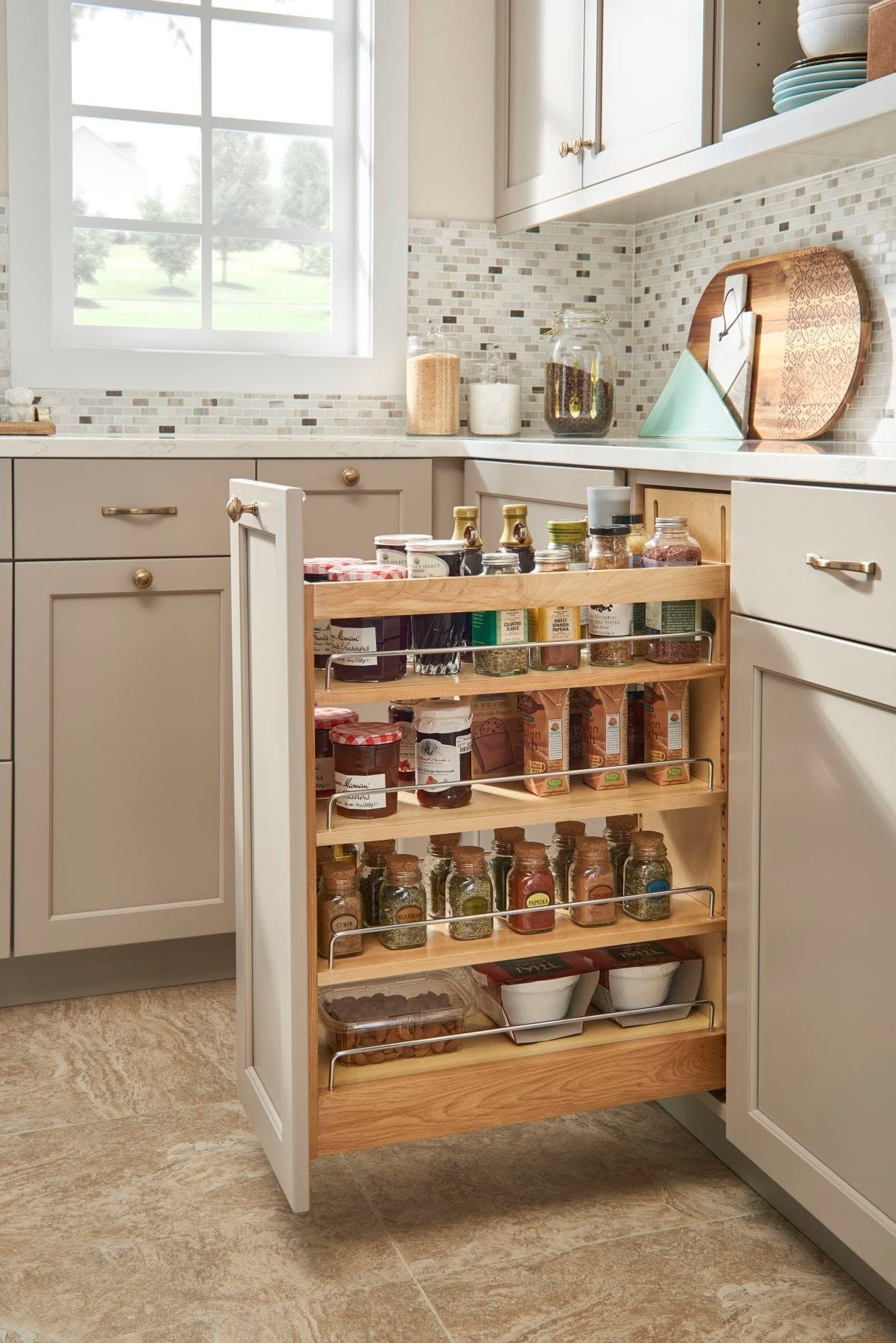 Kitchen cabinet pull-out spice rack in a bright white kitchen