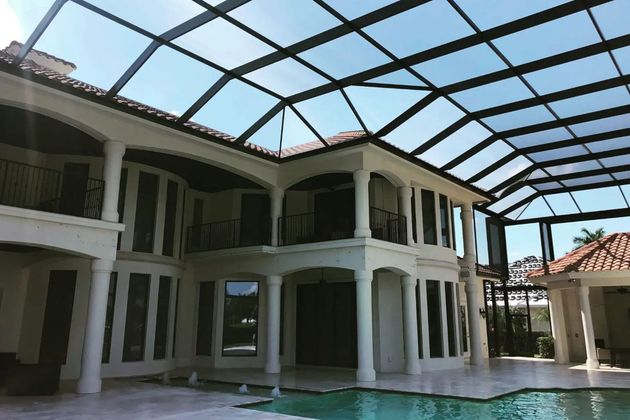 Open-air two-story house courtyard with a pool and glass-roofed patio