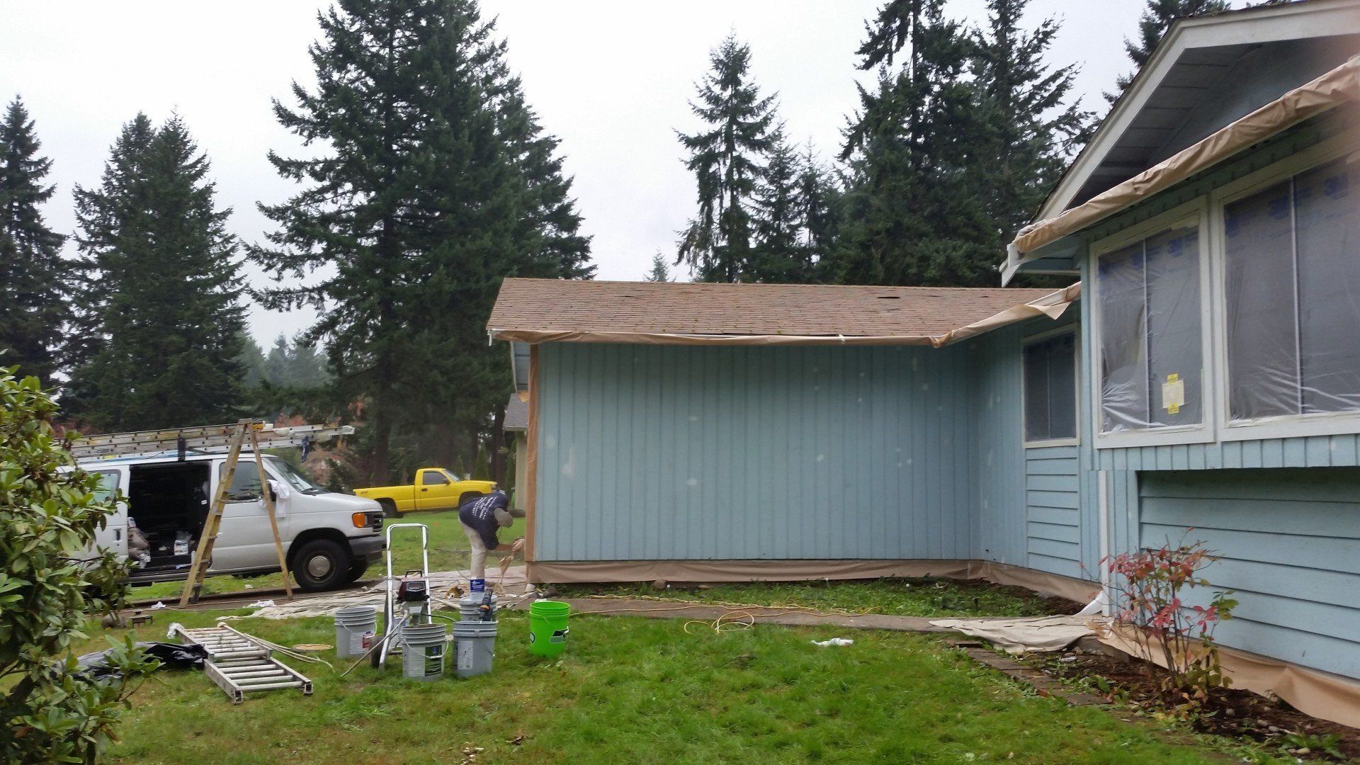 Painter working on the side of a house