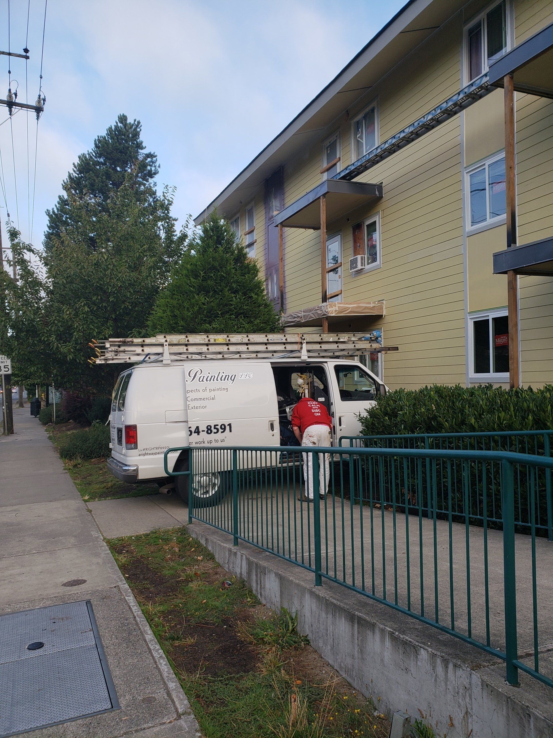 A Rightway Painting LLC's employee in front of a residential building