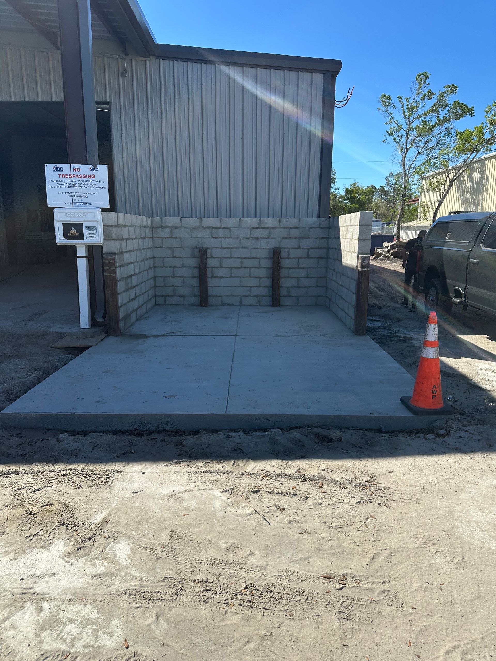 A truck is parked in front of a brick building next to a concrete area.