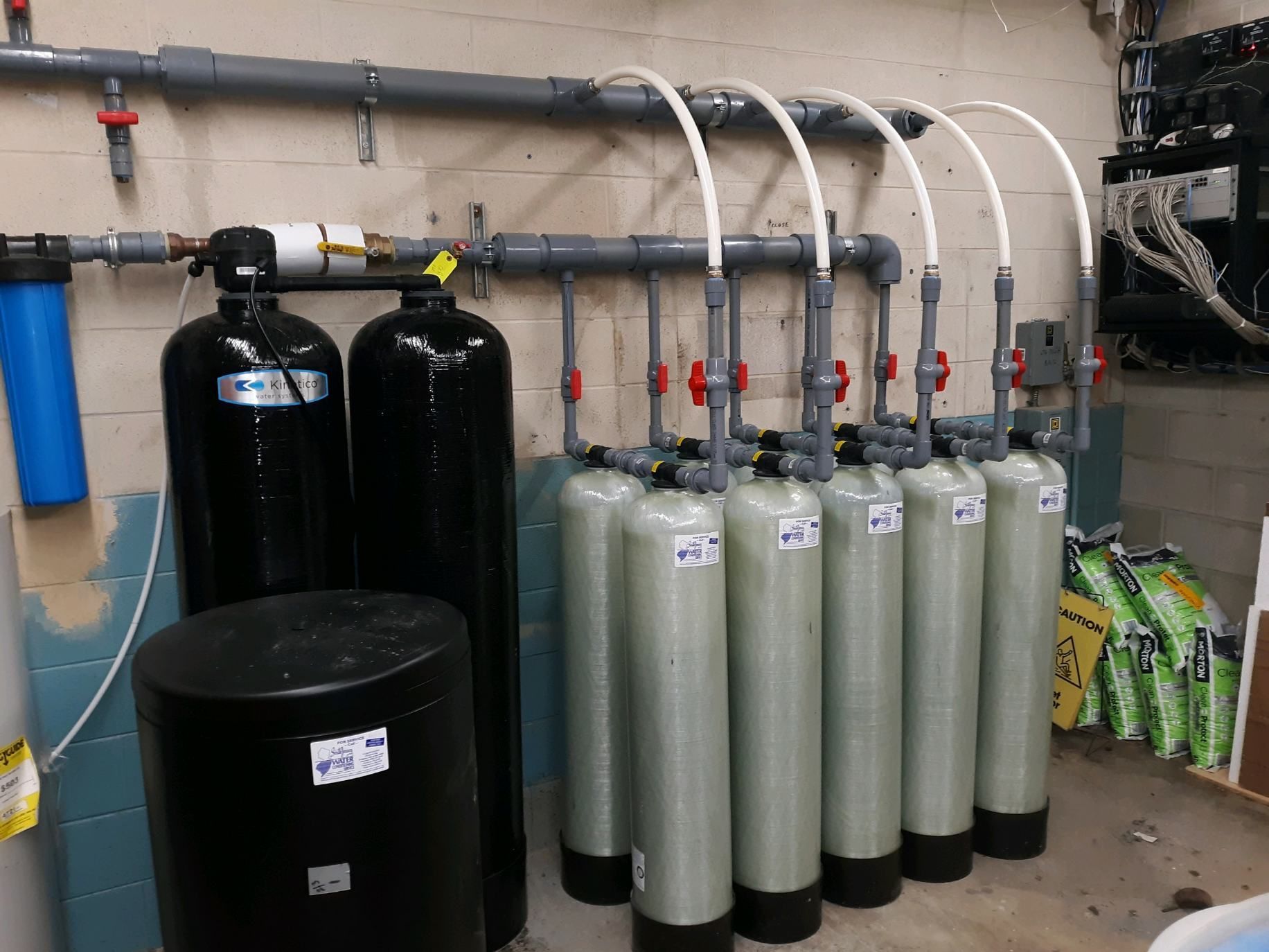 Water filtration system with multiple tanks and pipes in an industrial room