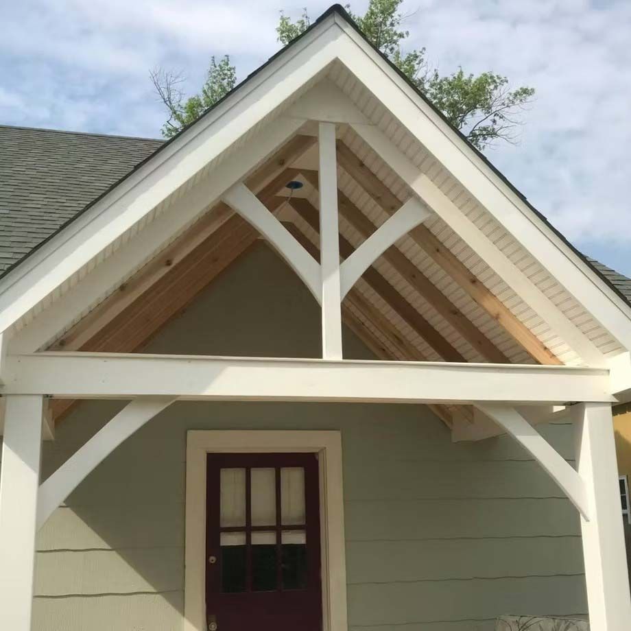 Front gable porch with white trim and green siding above a red door