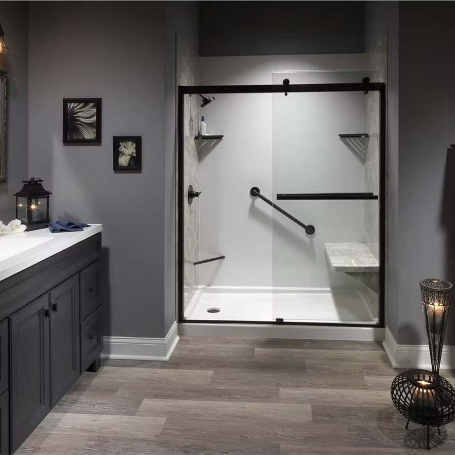 Accessible bathroom with walk-in shower, glass door, gray walls, and wood-look flooring.