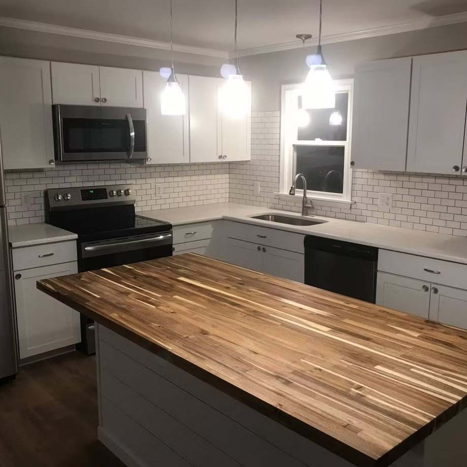 Modern kitchen with white cabinets, subway tile backsplash, stainless appliances, and a large wood island countertop