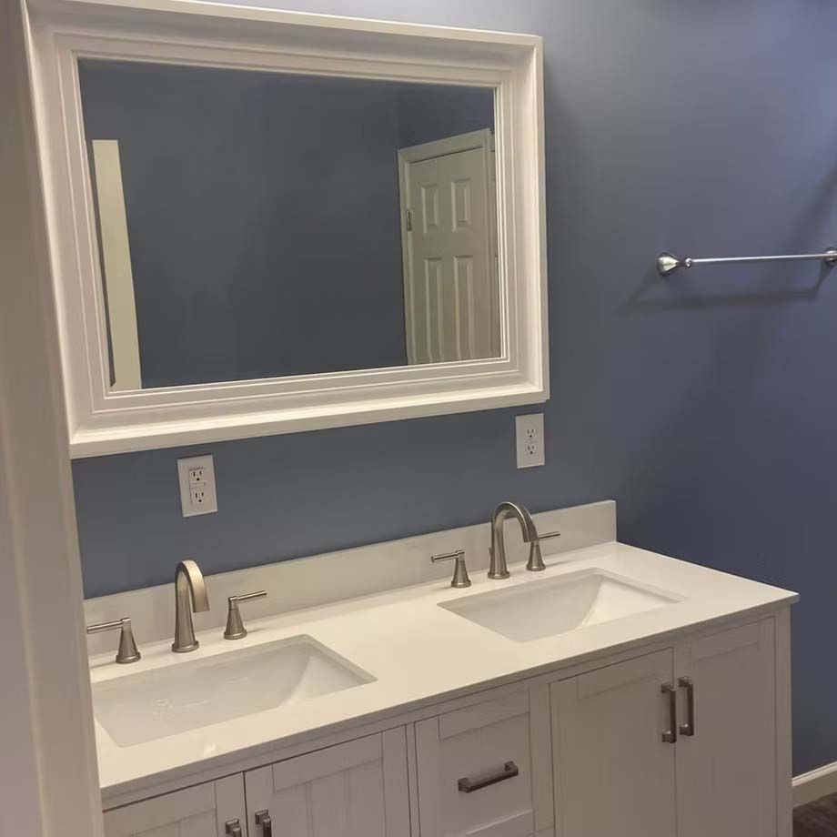 White double vanity with sinks and mirror in a blue bathroom