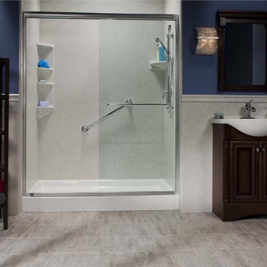 Accessible bathroom with glass shower enclosure, built-in shelves, and vanity sink.