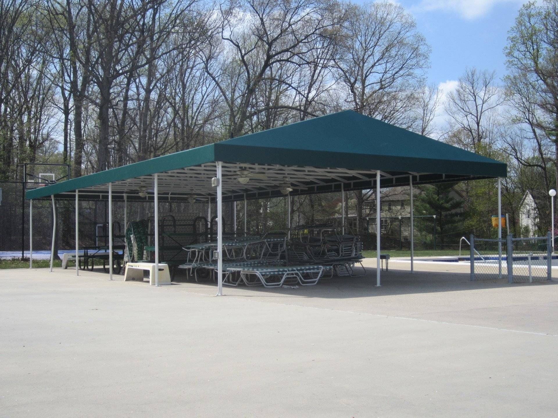 A large green tent is sitting in the middle of a parking lot.