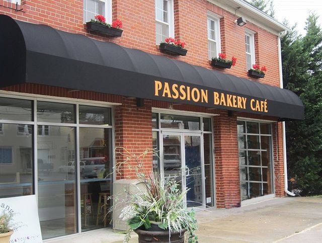 A brick building with a black awning that says Passion Bakery Cafe.