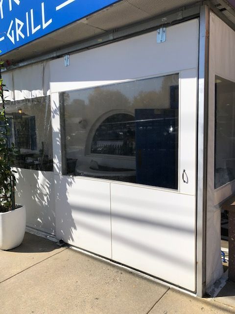 A white building with a blue sign that says Grill.