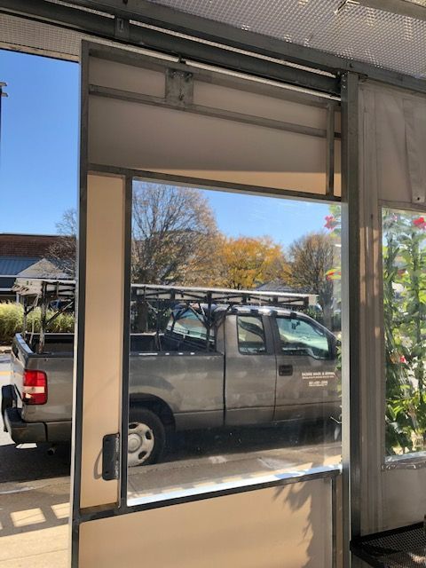 A truck is parked in front of a glass door.
