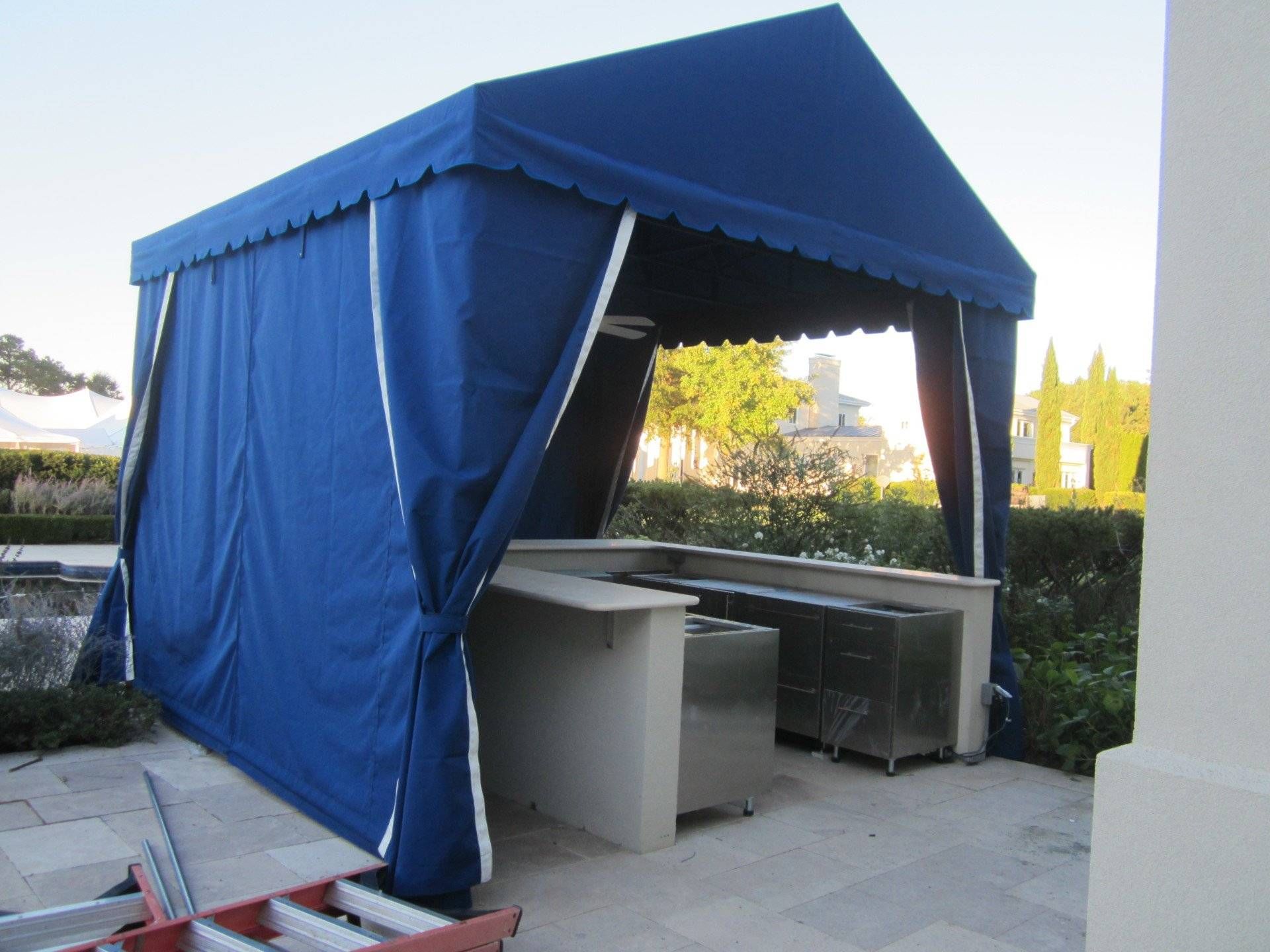 A blue tent with a ladder in front of it.