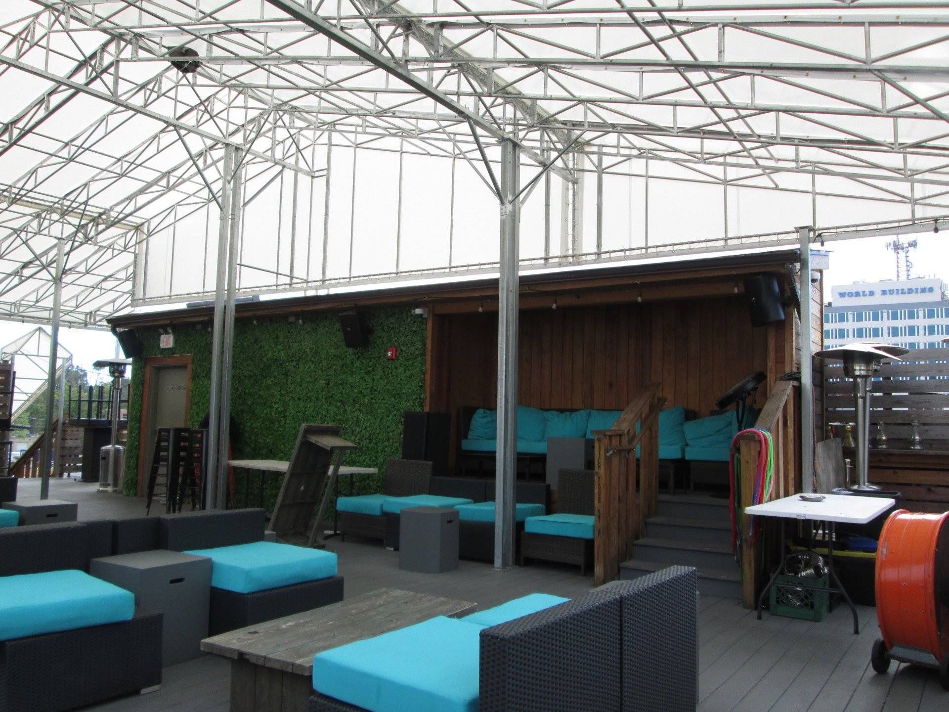 A rooftop area with a lot of furniture and tables.