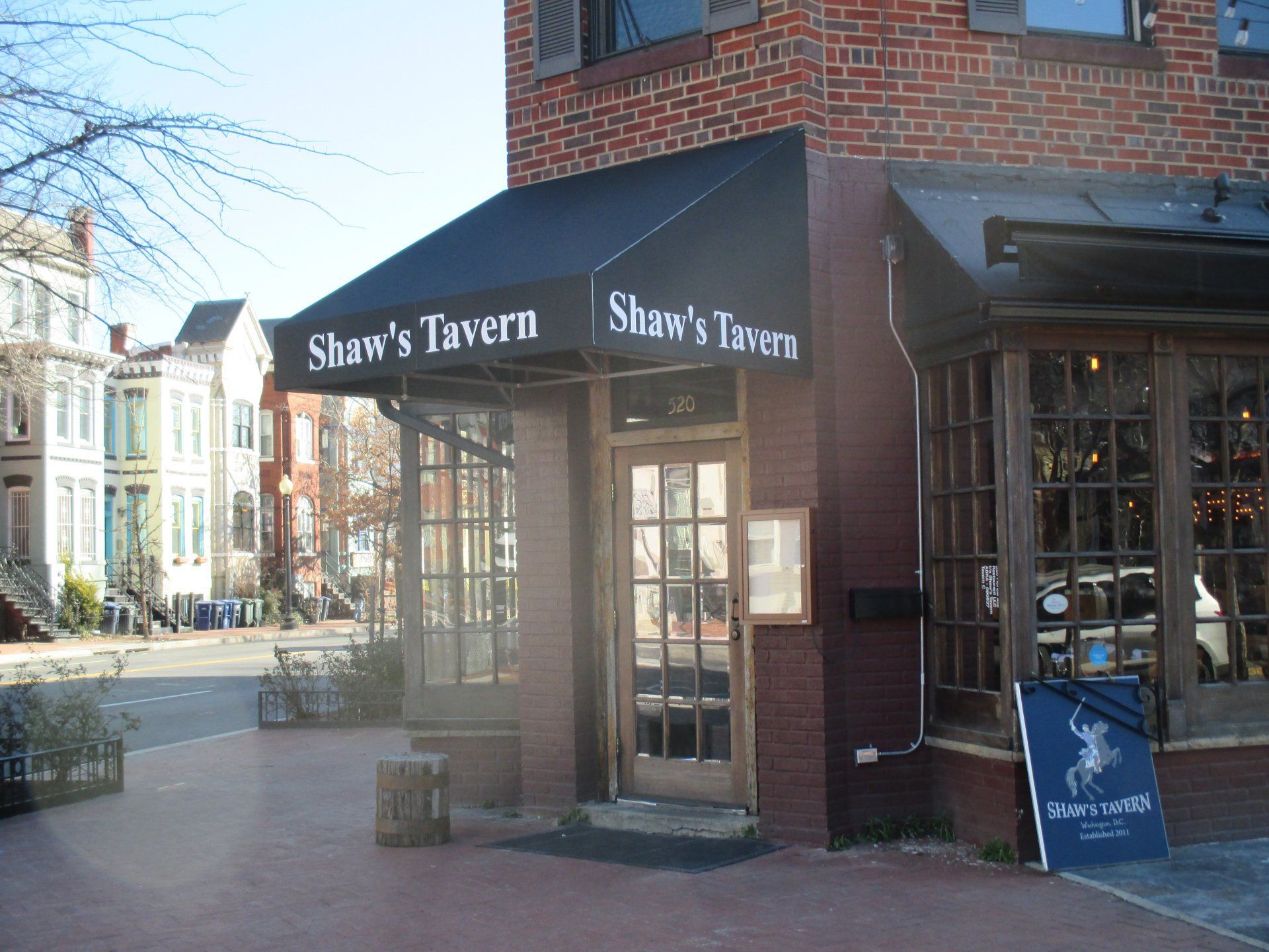 Shaw 's Tavern is located on the corner of a brick building.