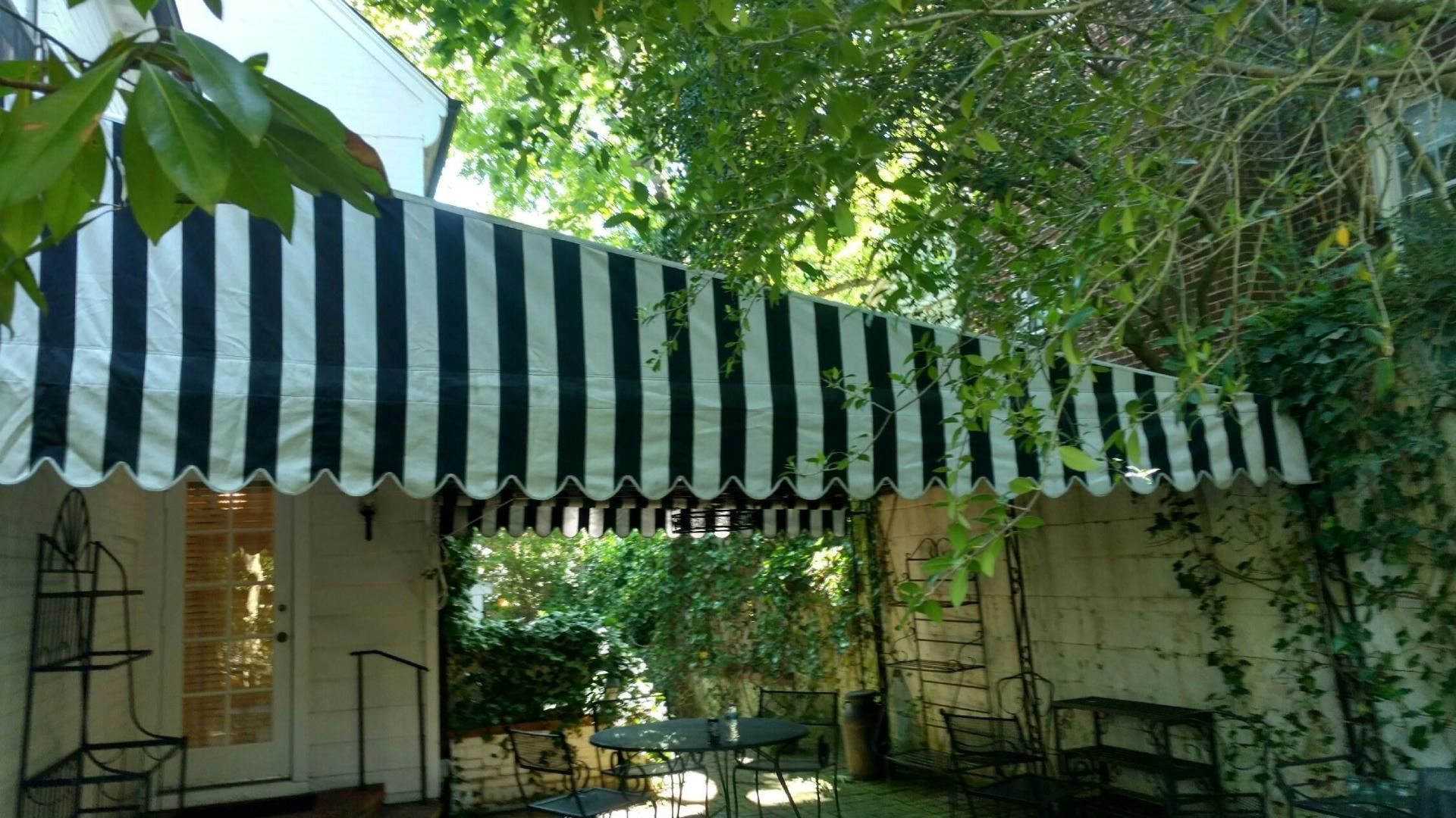 A black and white striped awning is hanging over a porch.