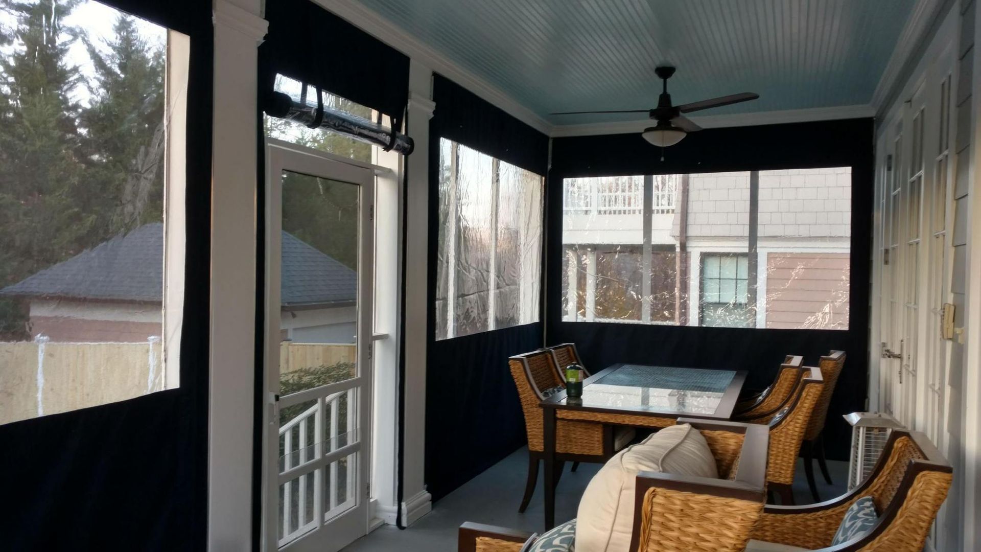 A screened in porch with a table and chairs.
