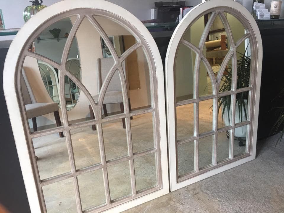 Two arched decorative mirrors with white frames and grid details.