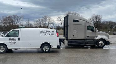 McCool Semi Repair & Roadside Services' white service van and gray towing truck