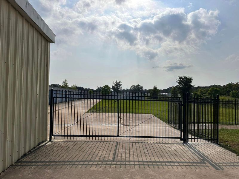 Metal gate in front of a storage facility on a sunny day.