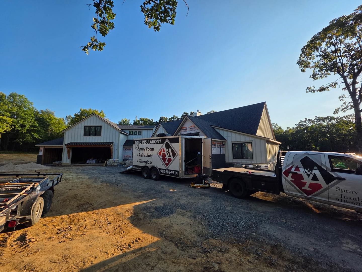 Construction site: House with trailer, truck, and equipment. Exterior, sunny day.