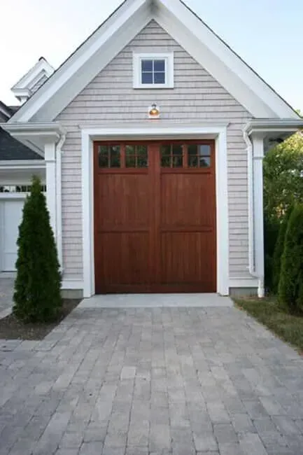Gray house with a large brown garage door and paver driveway