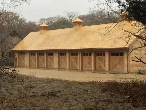 Long tan building with a sloped roof and small towers in a dry, wooded setting