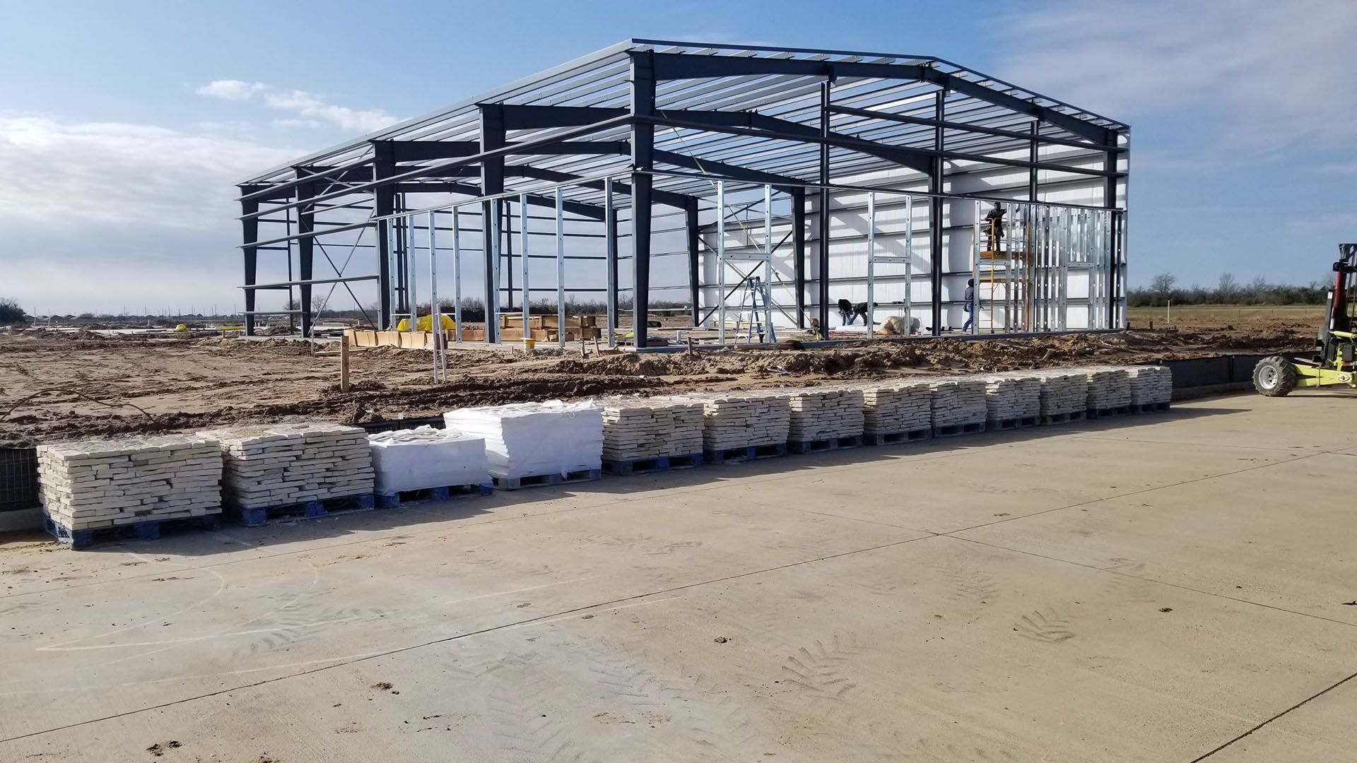 A large metal structure is being built in a field.