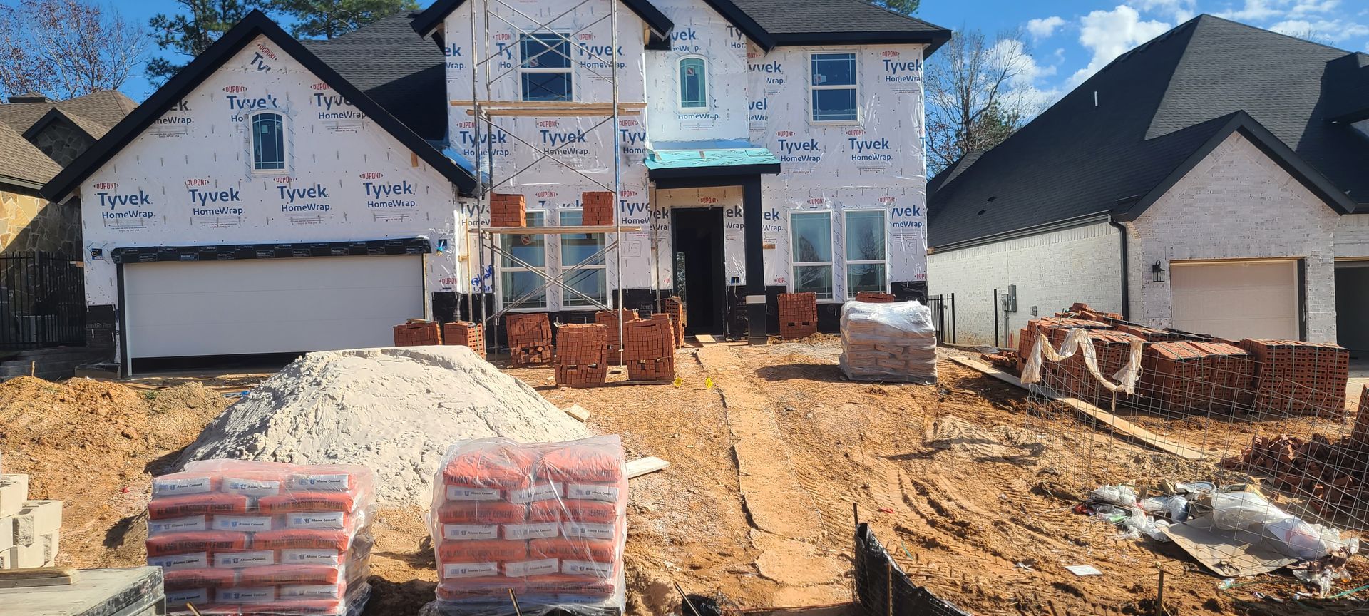 A large white house is being built in a residential area.