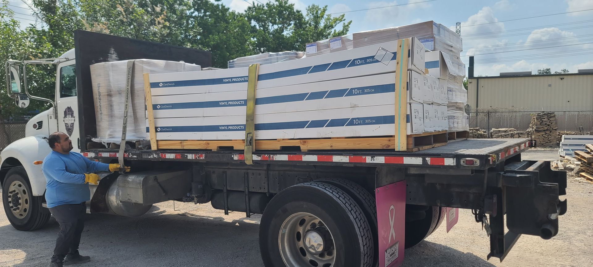 A man is loading a truck with boxes on the back.