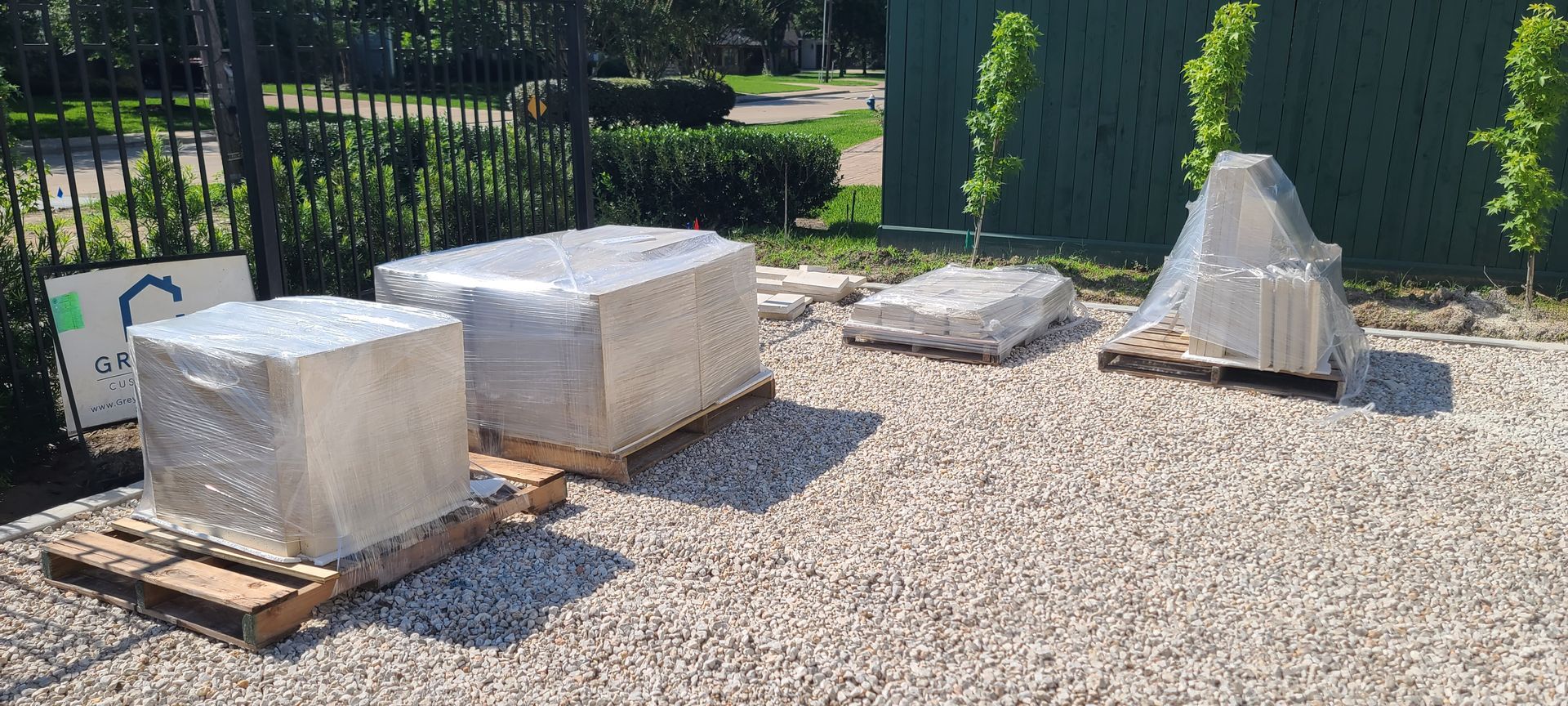 A group of boxes sitting on top of wooden pallets on gravel.