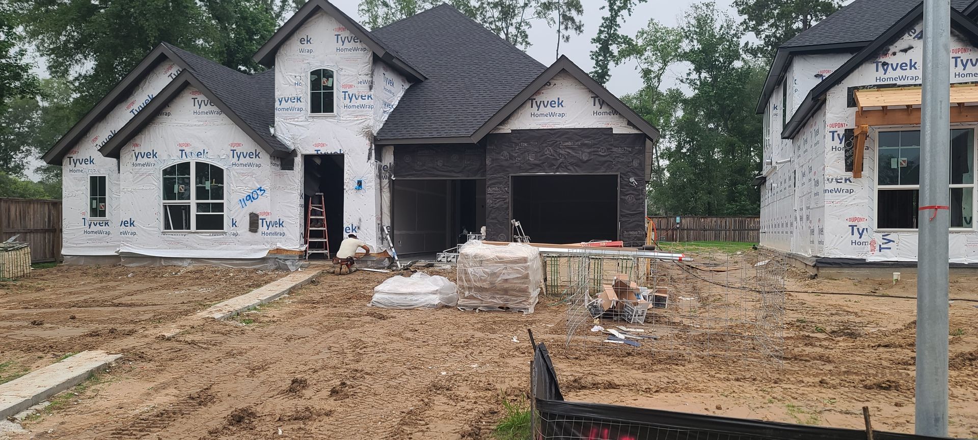 A house is being built in the middle of a dirt field.