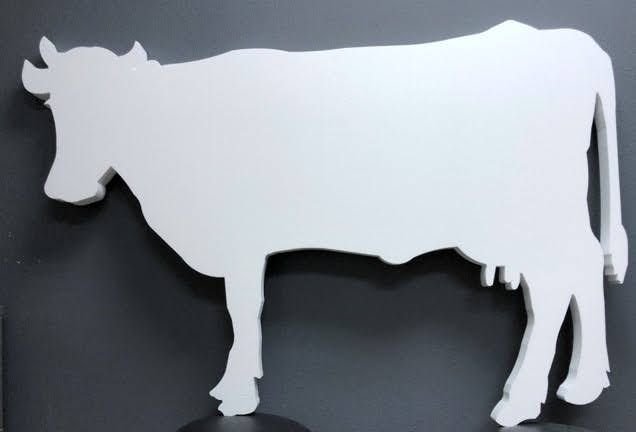 A white silhouette of a cow on a black background