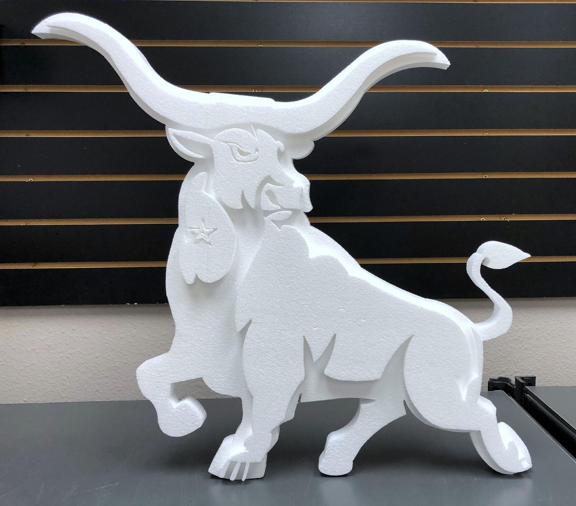 A statue of a bull with long horns is sitting on a table