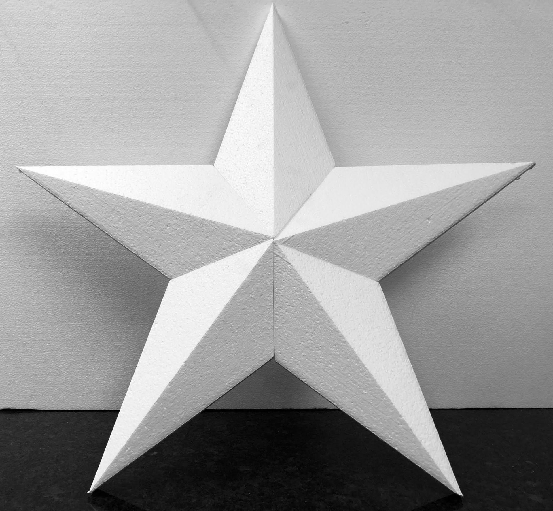 A white star made of styrofoam is sitting on a table