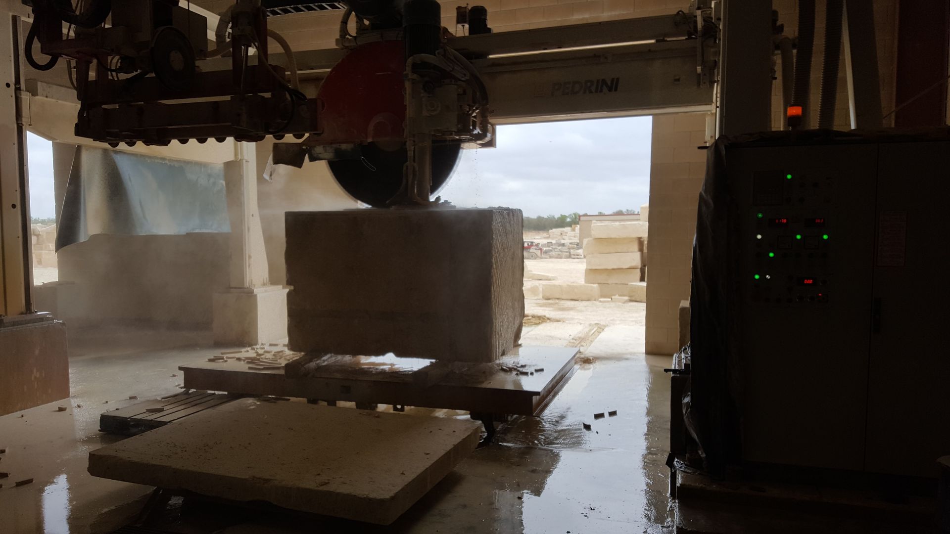 A machine is cutting a block of stone in a factory