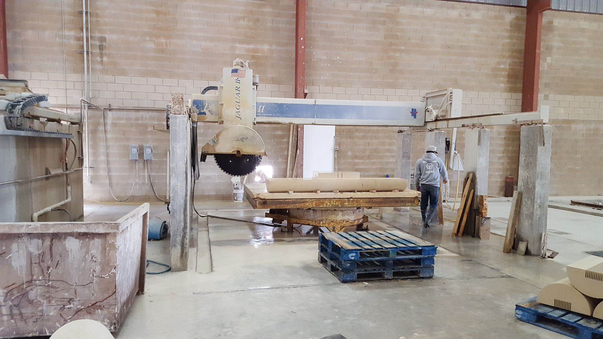 A man is standing next to a machine in a warehouse.