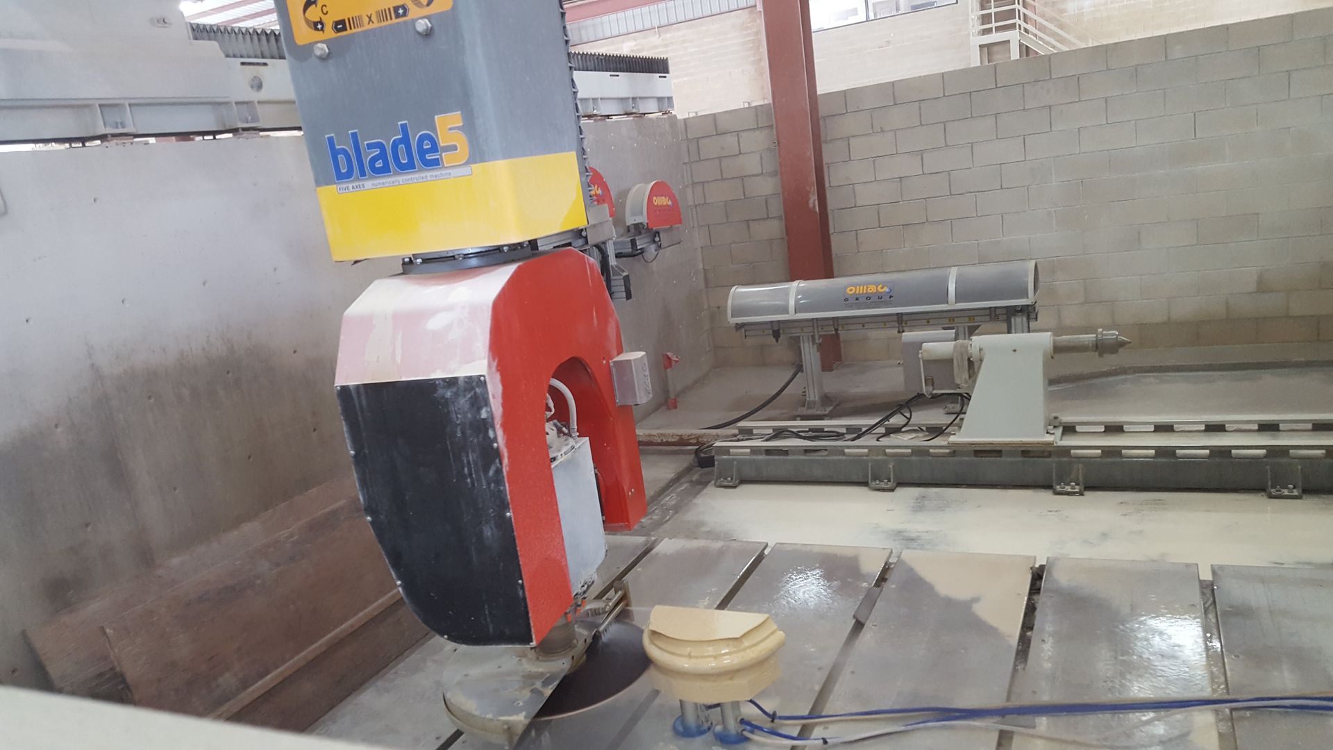 A machine is cutting a piece of stone in a factory.
