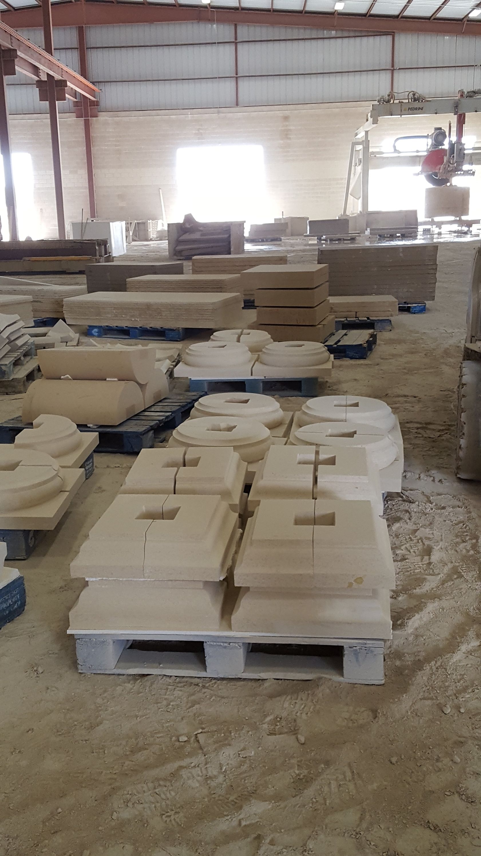 A warehouse filled with lots of concrete blocks on pallets.