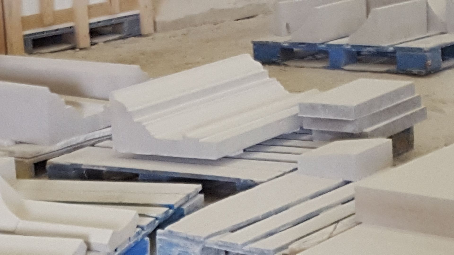 A bunch of white blocks are sitting on top of each other on pallets.
