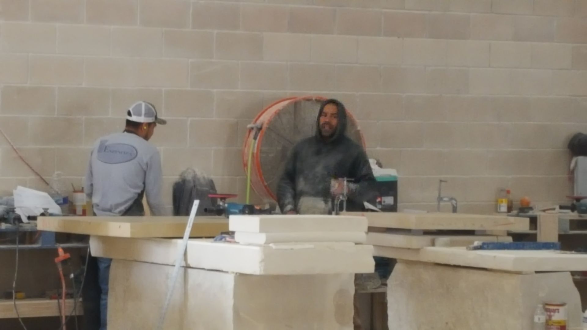 Two men are working on a counter in a building.