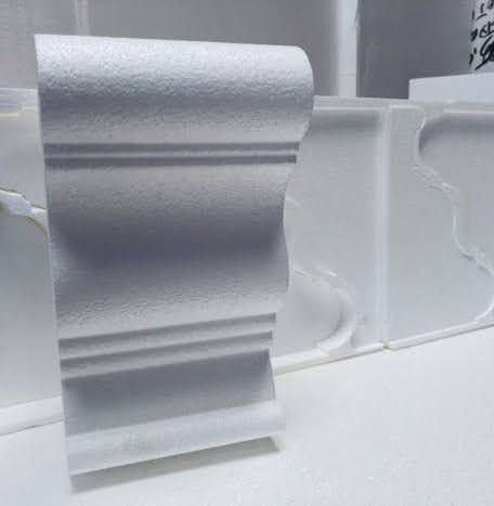 A white molding is sitting on top of a white table.