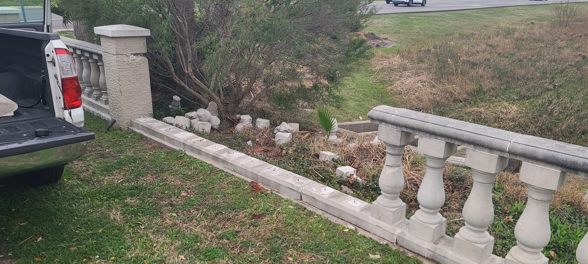A truck is parked next to a concrete fence.