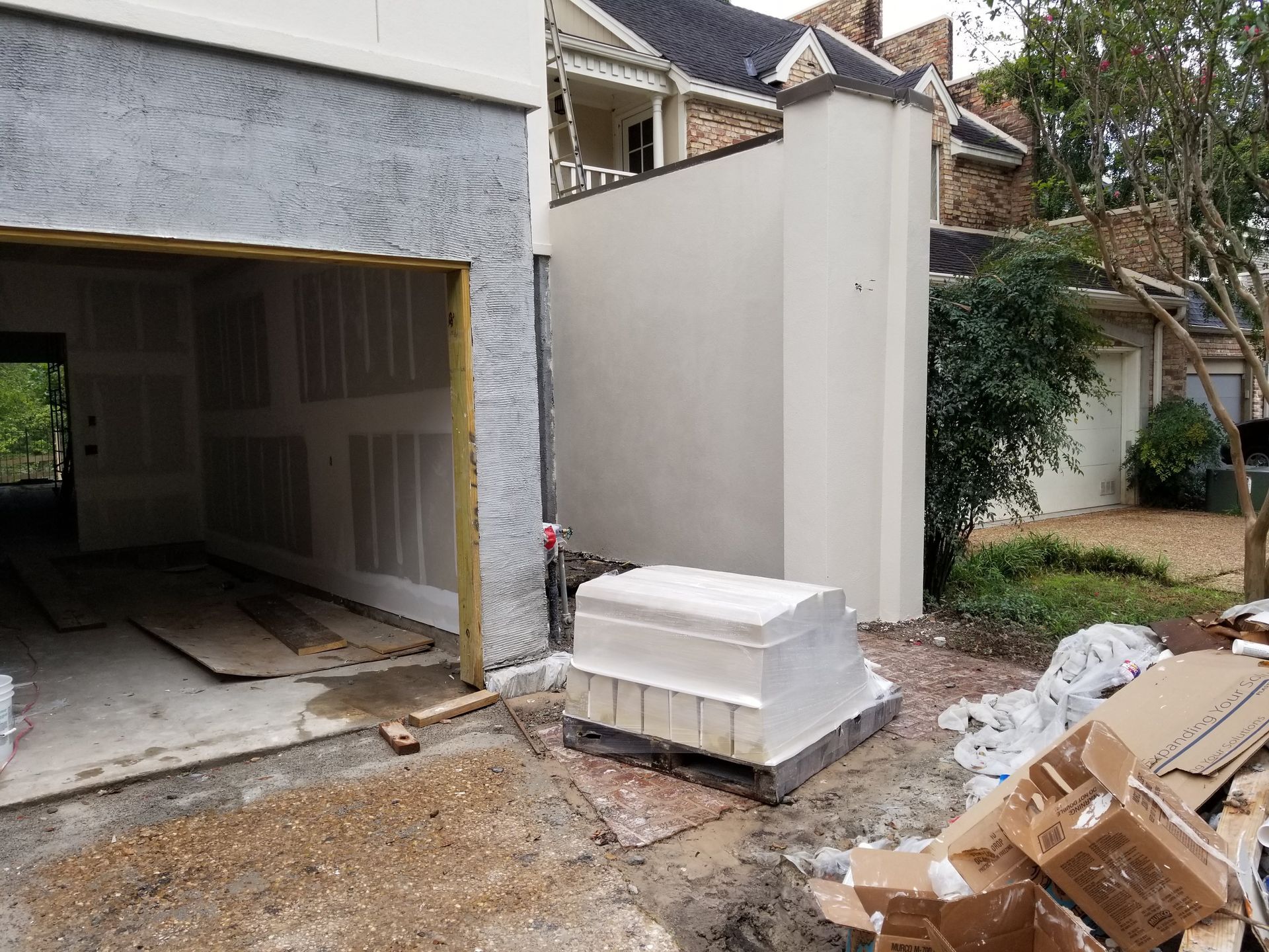 A garage door is being built next to a house.