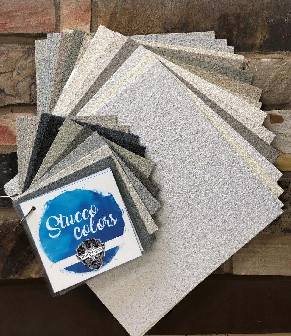 A bunch of papers are stacked on top of each other in front of a brick wall.