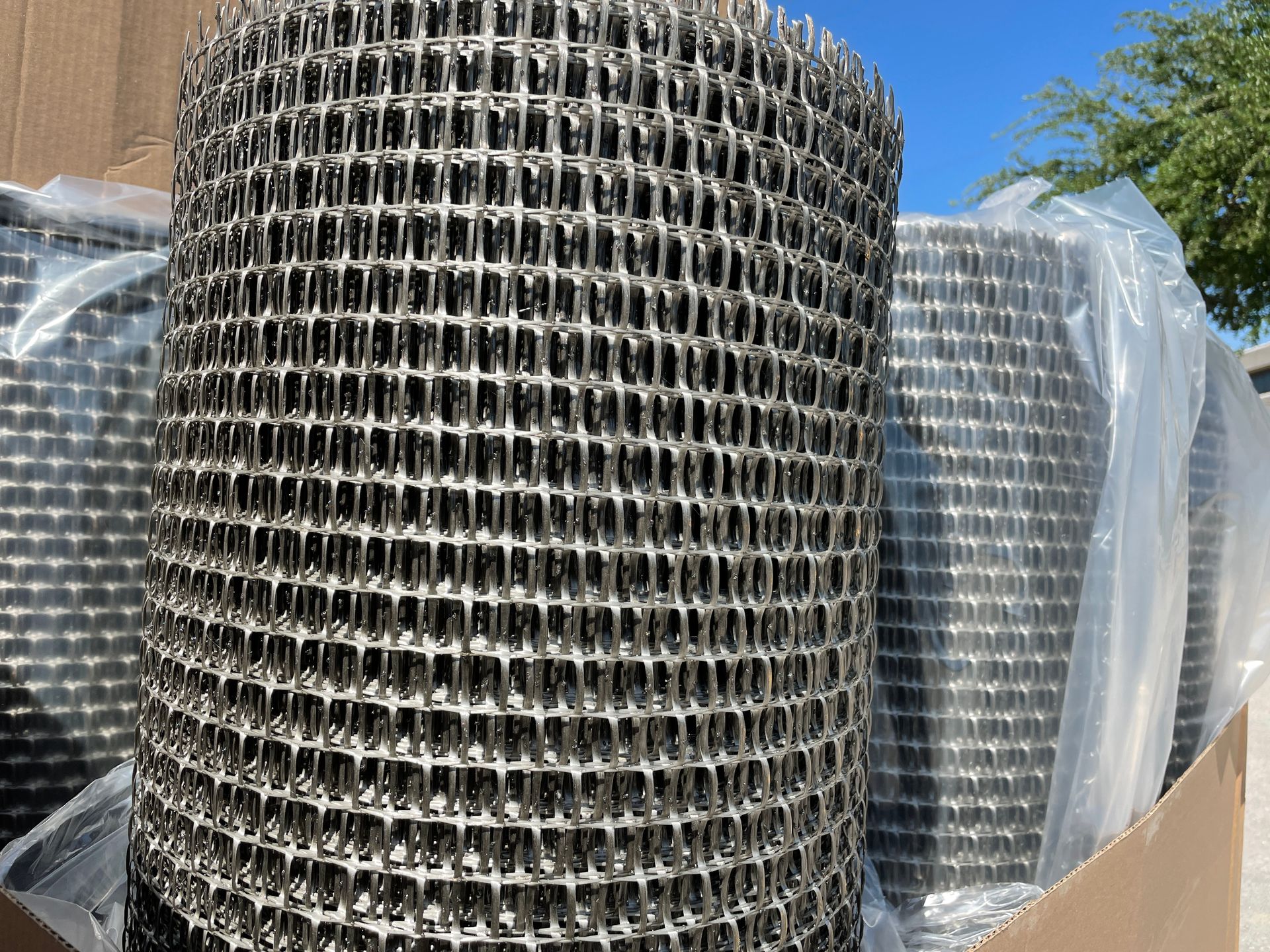 A roll of wire mesh is sitting on top of a cardboard box.