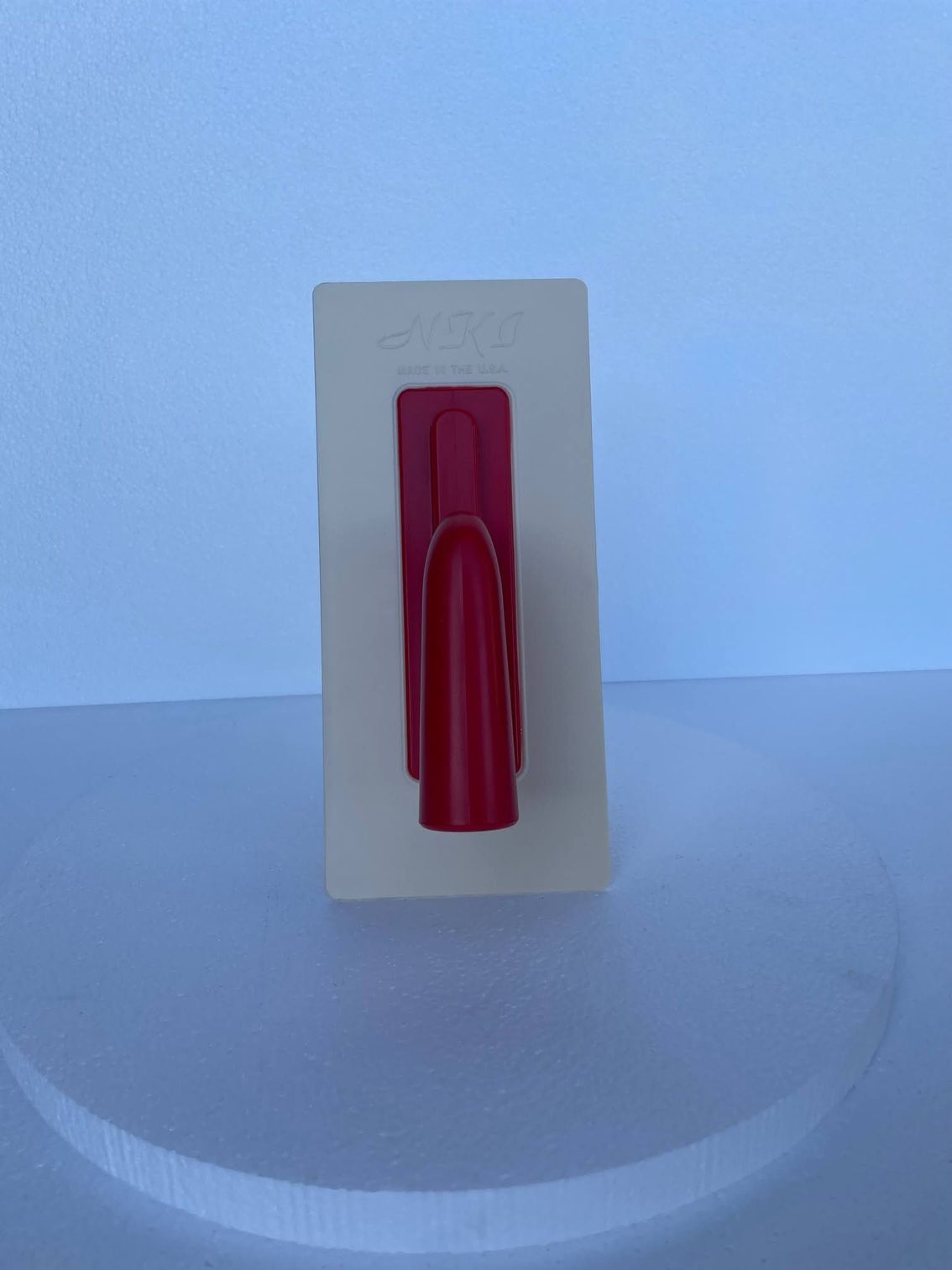 A red object is sitting on top of a white surface.